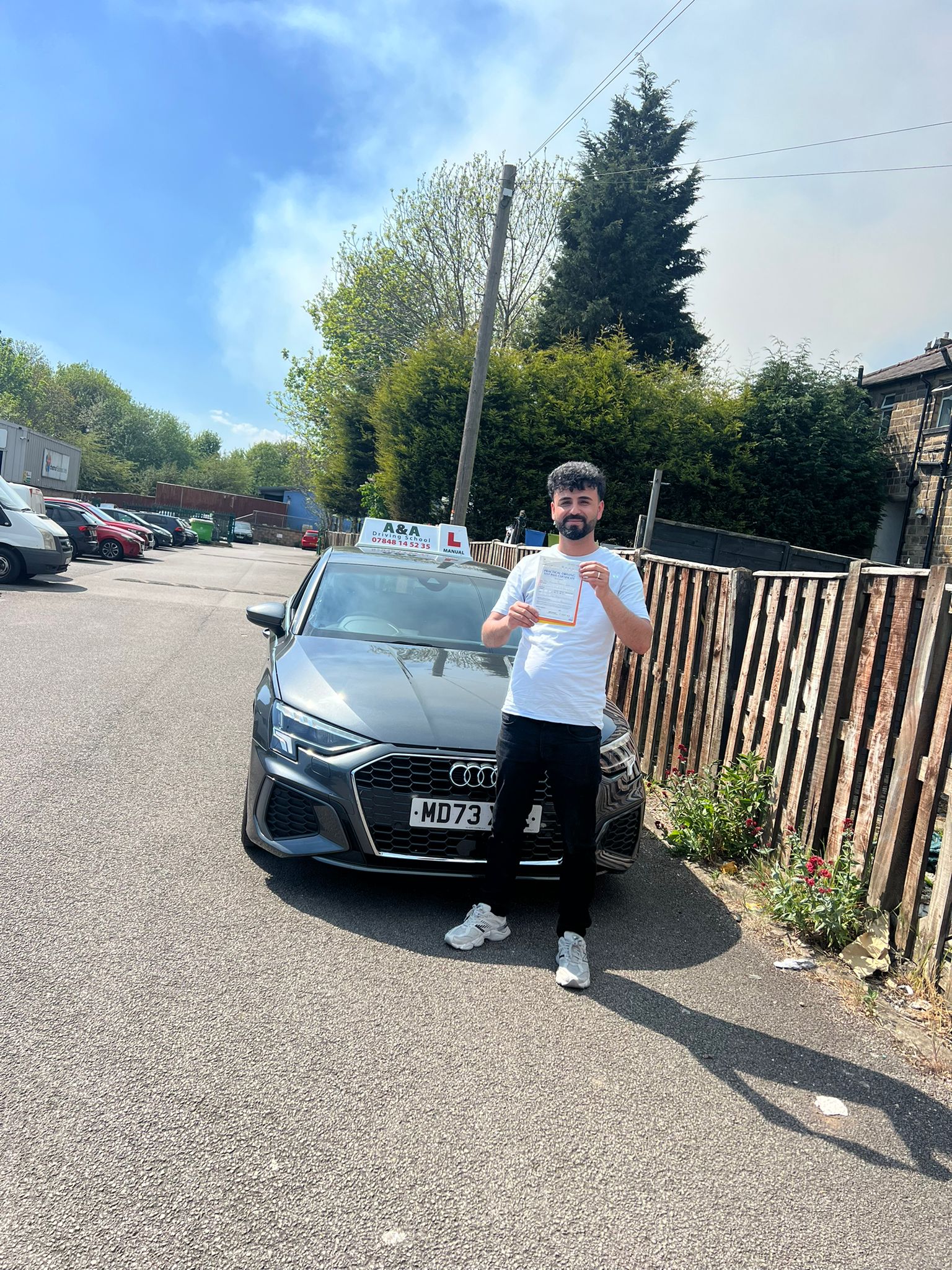 Person holding certificate by car