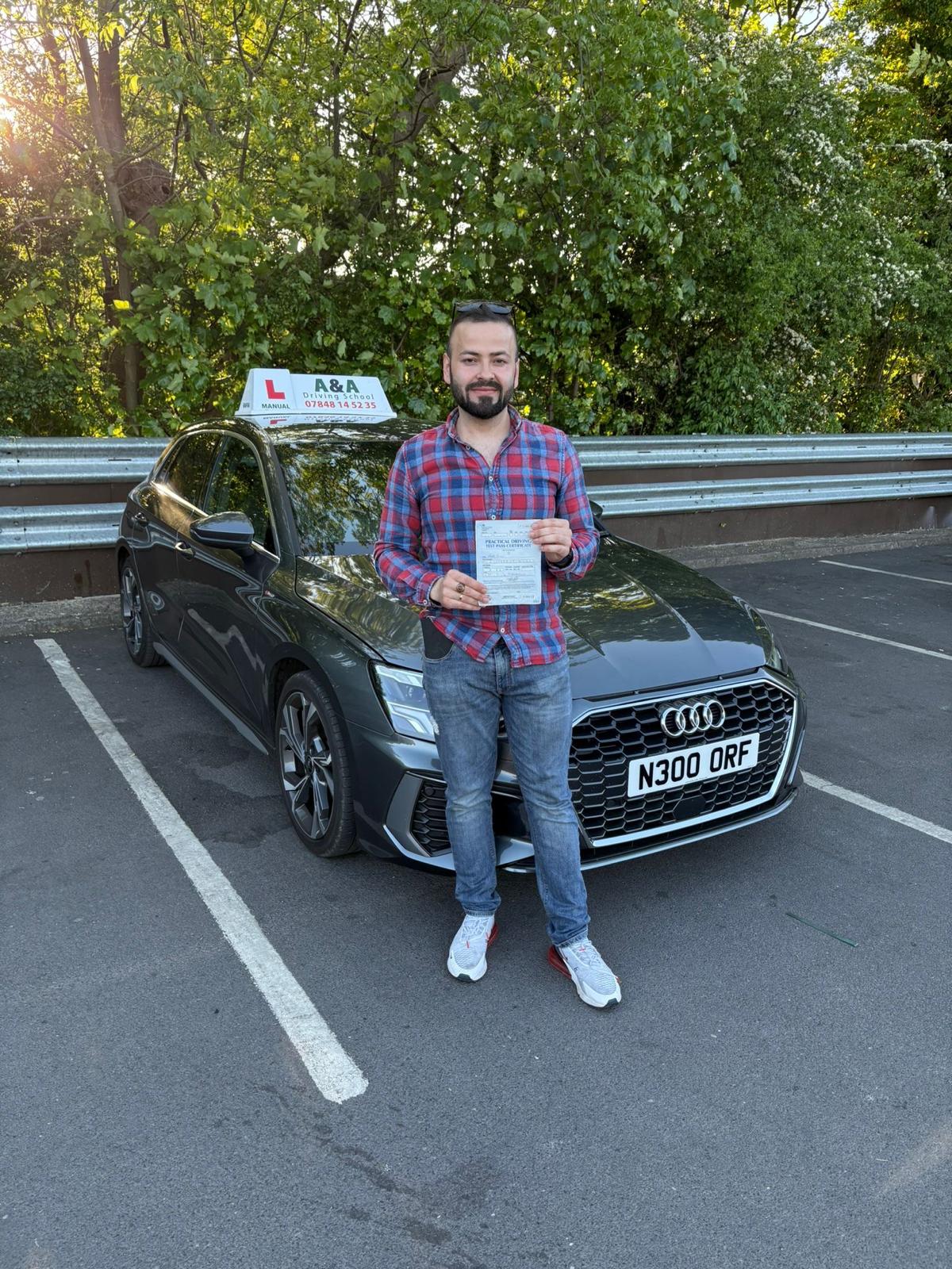 Man holding driving test certificate by car