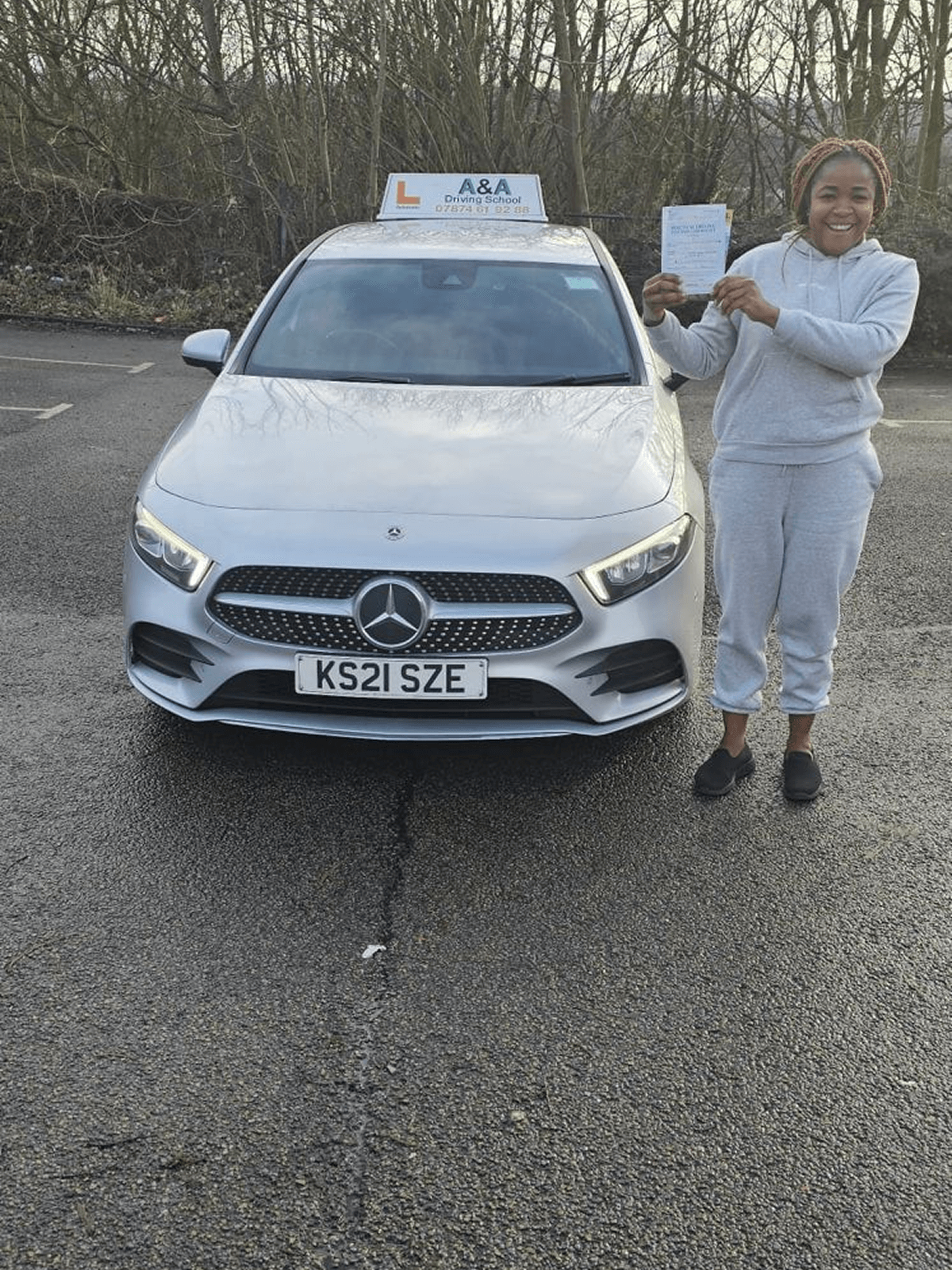 Person holding certificate next to car