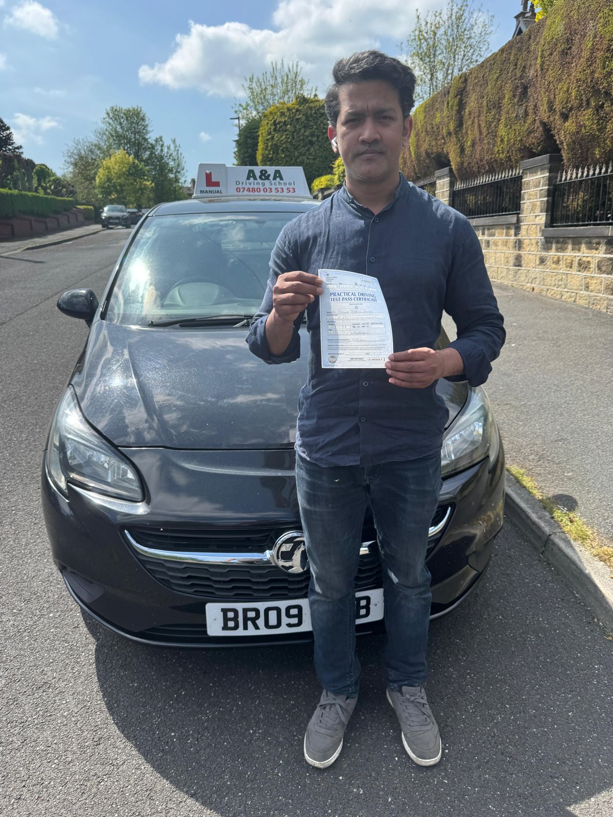 Person holding driving test certificate outdoors