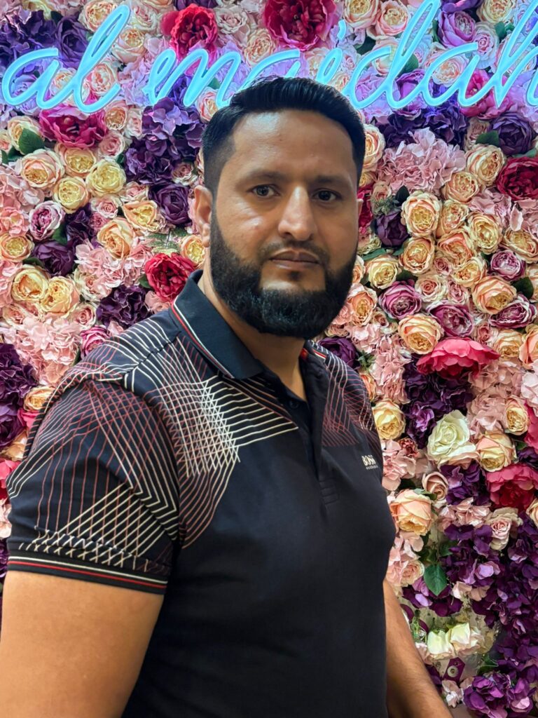 Man in front of floral backdrop